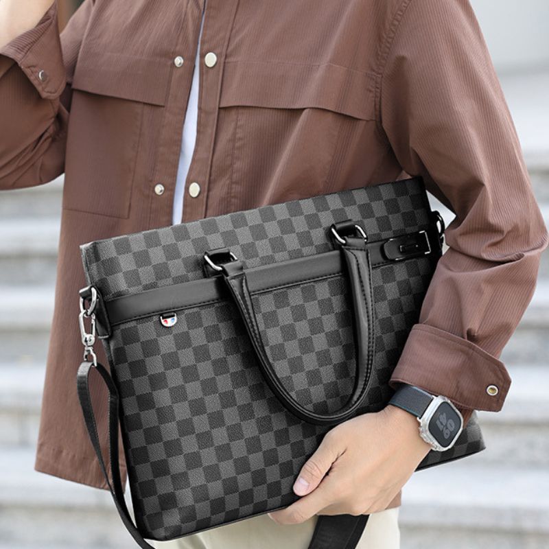 Person holding a gray checkered handbag with a blurred background