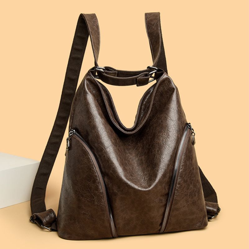 Brown leather backpack on a beige background