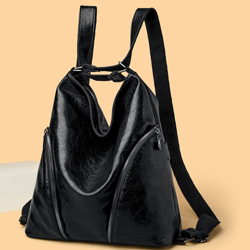 Black leather backpack on a beige background
