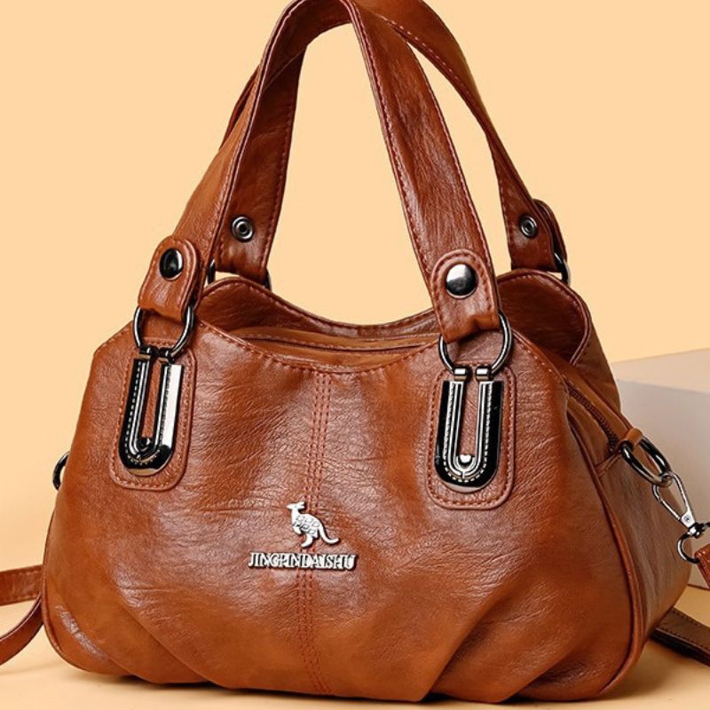 Brown handbag with a visible brand logo on a beige background
