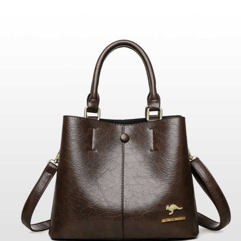 Brown leather handbag with a visible brand logo on a light gray background