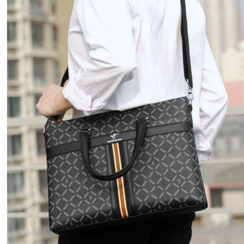 Person holding a gray patterned briefcase with a building in the background