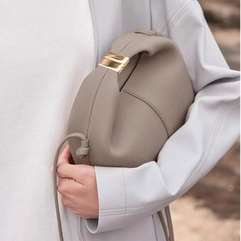 Close-up of a beige backpack with a gold zipper on a blurred background