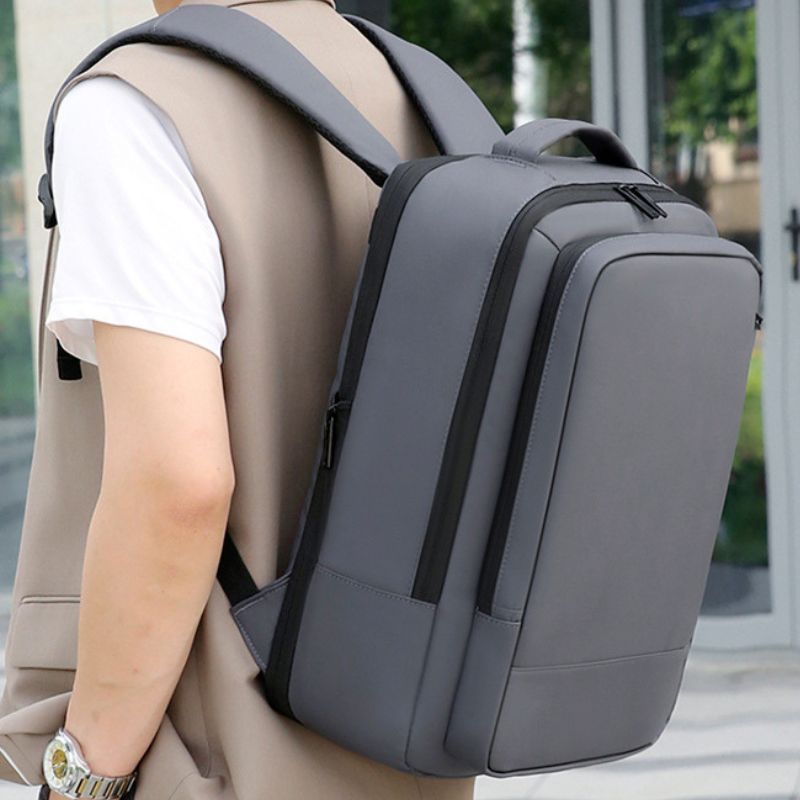 Person wearing a gray backpack with a blurred background