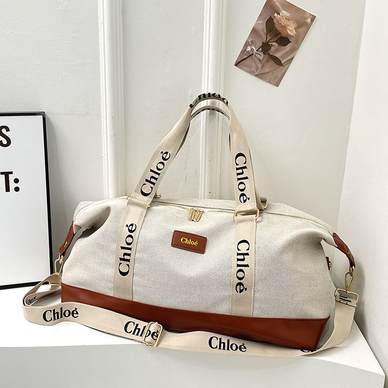 A beige and brown Oxford travelling handbag with adjustable shoulder strap, placed against a white background with the brand name 'Chloe' visible on the strap.