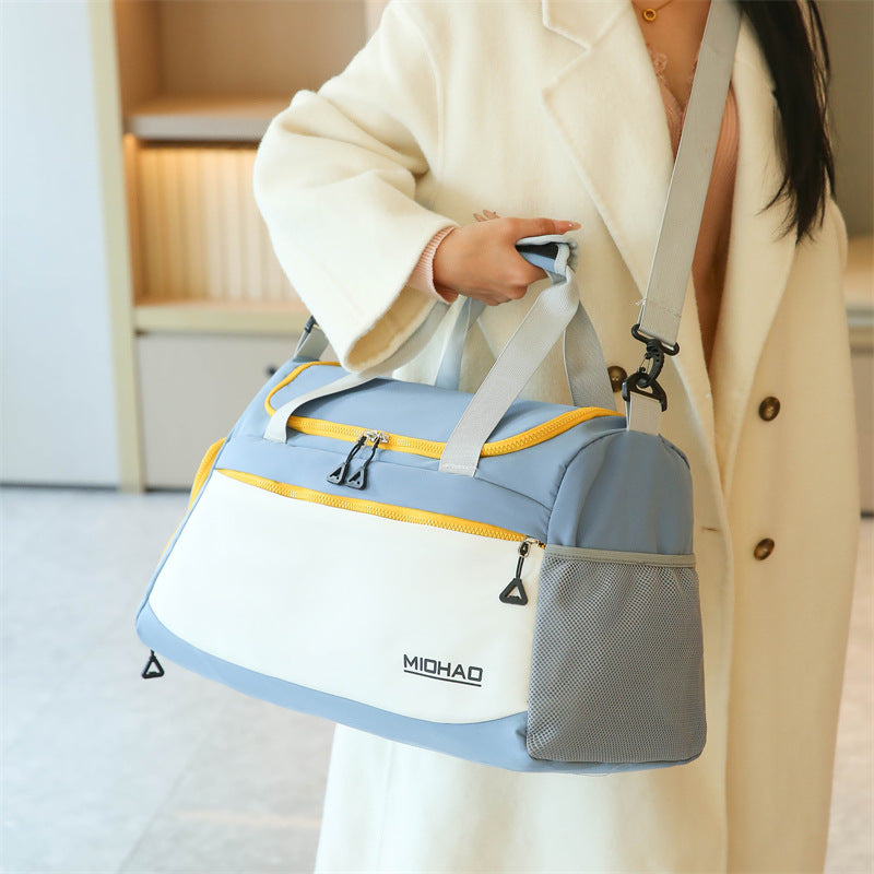 Woman wearing white long coat hanging the premium duffle bag using the side shoulder strap.
