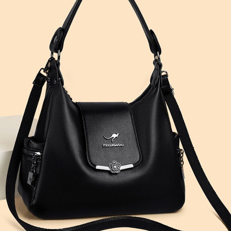 Black handbag with a visible brand logo on a beige background