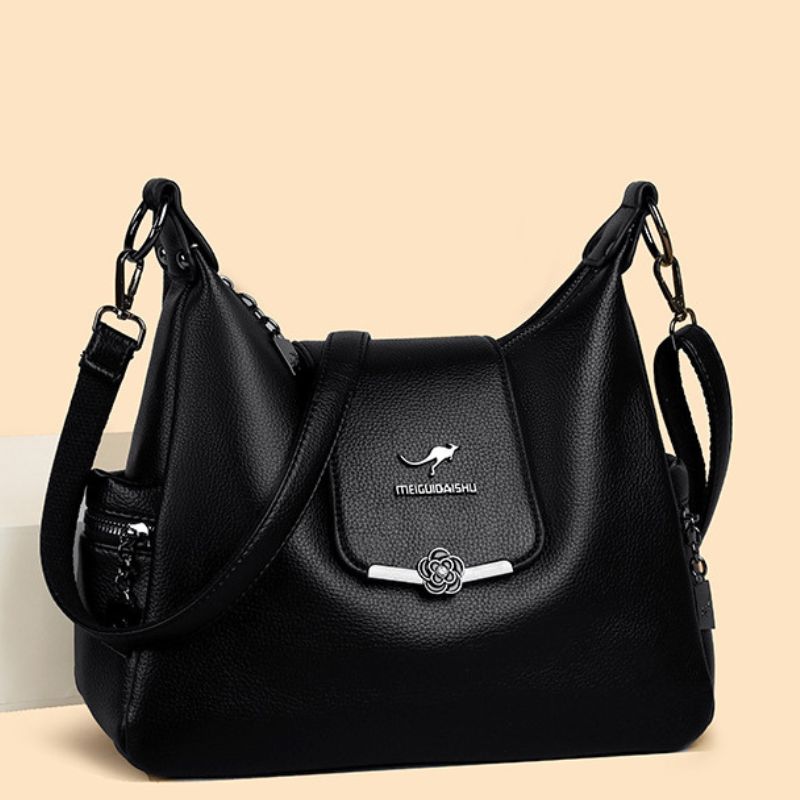 Black handbag with a visible brand logo on a beige background