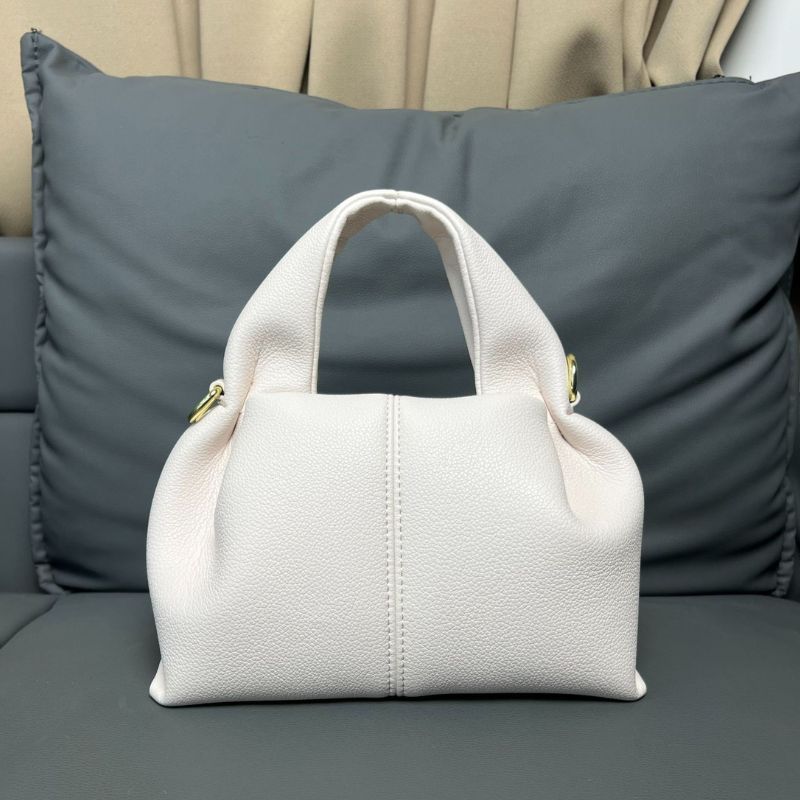 White handbag on a gray couch with pillows