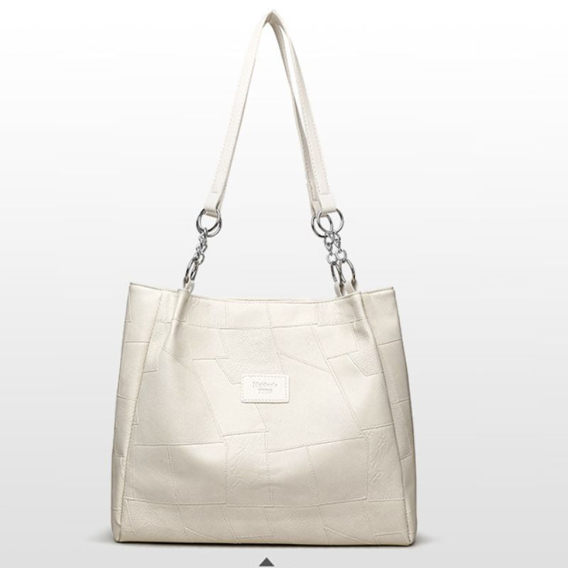 Beige handbag with a textured pattern on a light gray background