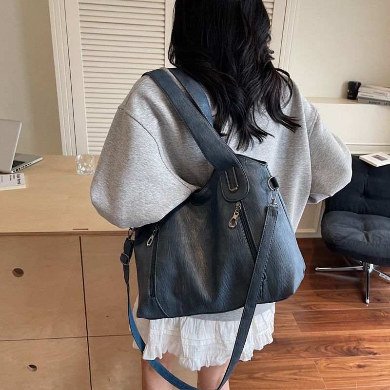 Person wearing a black backpack in an indoor setting