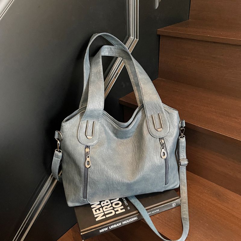 Blue handbag on a book with a staircase in the background