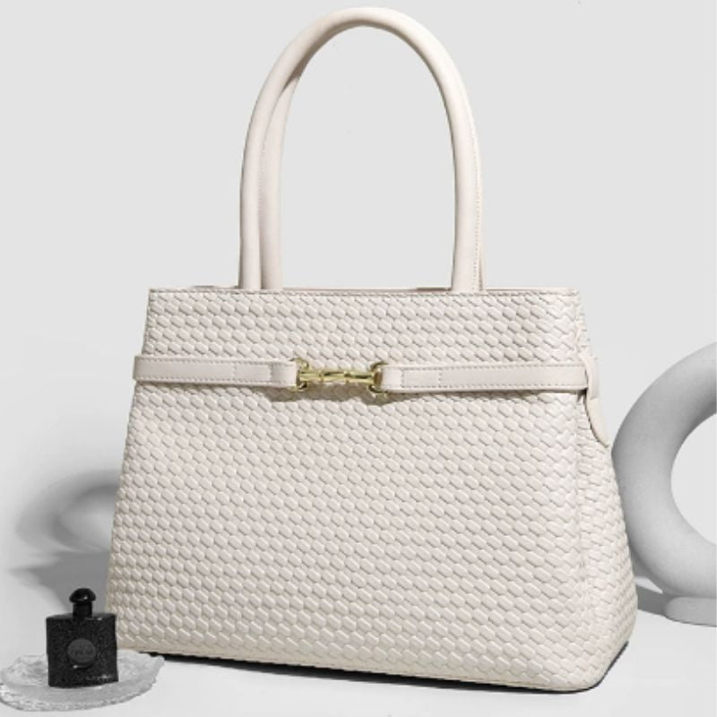 White woven handbag with a gold clasp on a light gray background