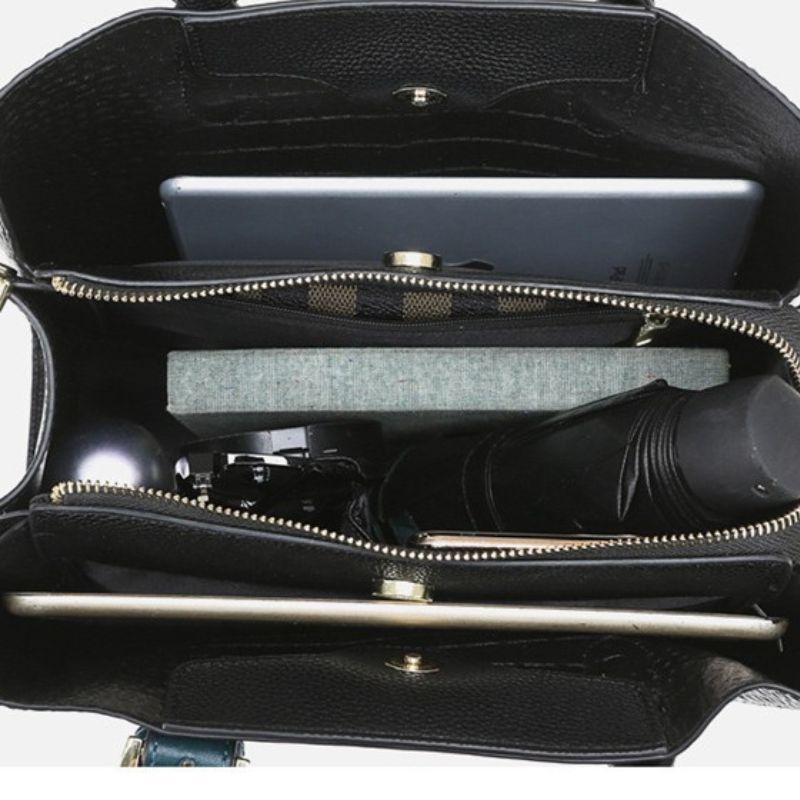 Black leather handbag with a visible interior and handle on a white background