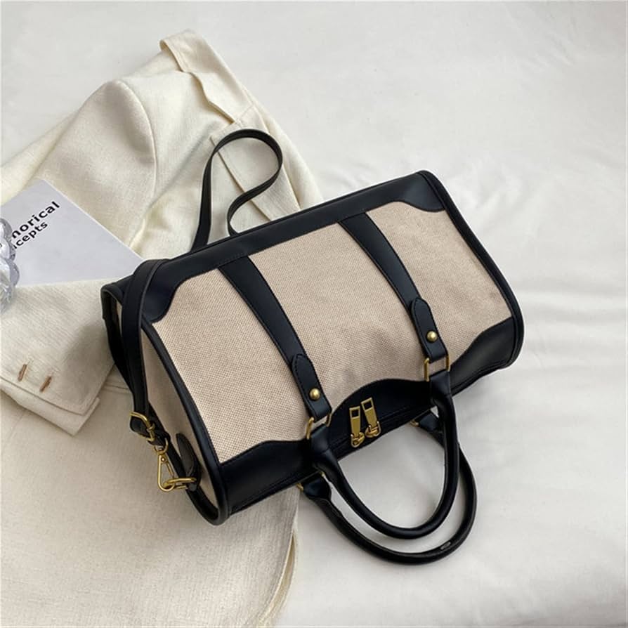 Elegant beige and black leather duffle handbag with gold accents and detachable strap by DYP Lifestyle, placed on a white surface beside a cream blazer — a modern luxury travel and office bag for men and women