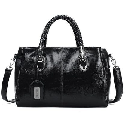 Black leather handbag with braided handle on a white background