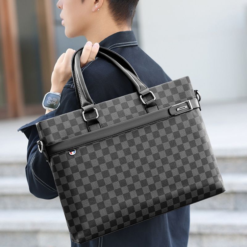 Person holding a gray checkered briefcase with a blurred background