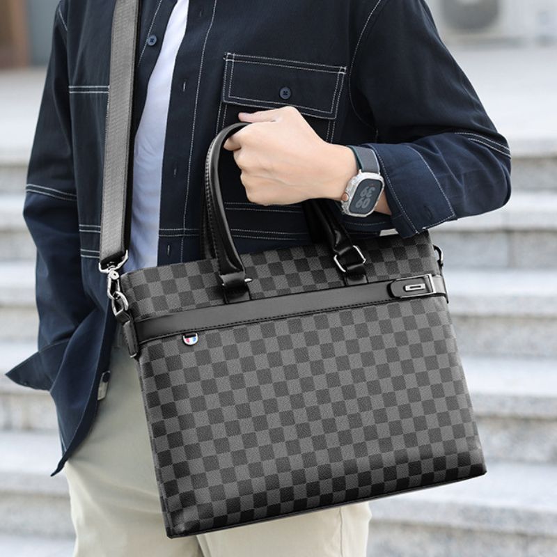Person holding a gray checkered handbag with a blurred background