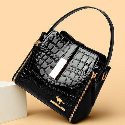 Black quilted handbag with gold accents on a beige background