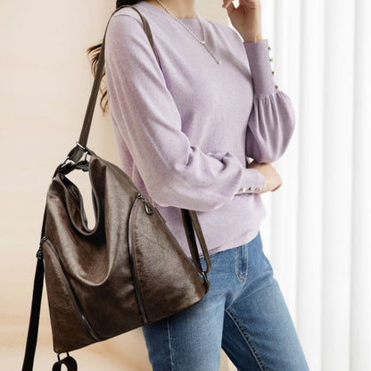 Person wearing a brown leather handbag with a neutral background