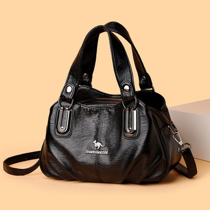 Black handbag with silver hardware on a beige background