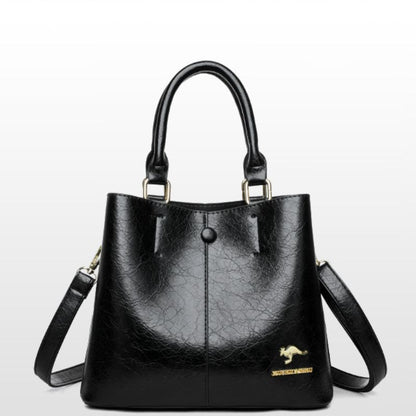 Black handbag with a strap on a light gray background