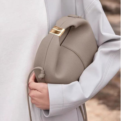 Close-up of a beige backpack with a gold zipper on a blurred background