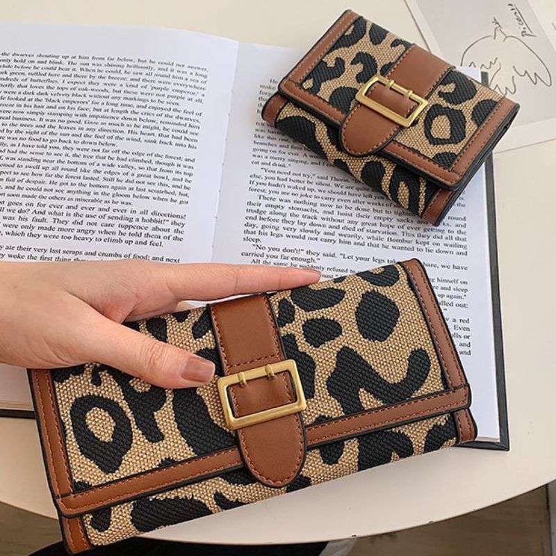 Leopard print wallet with brown accents on an open book