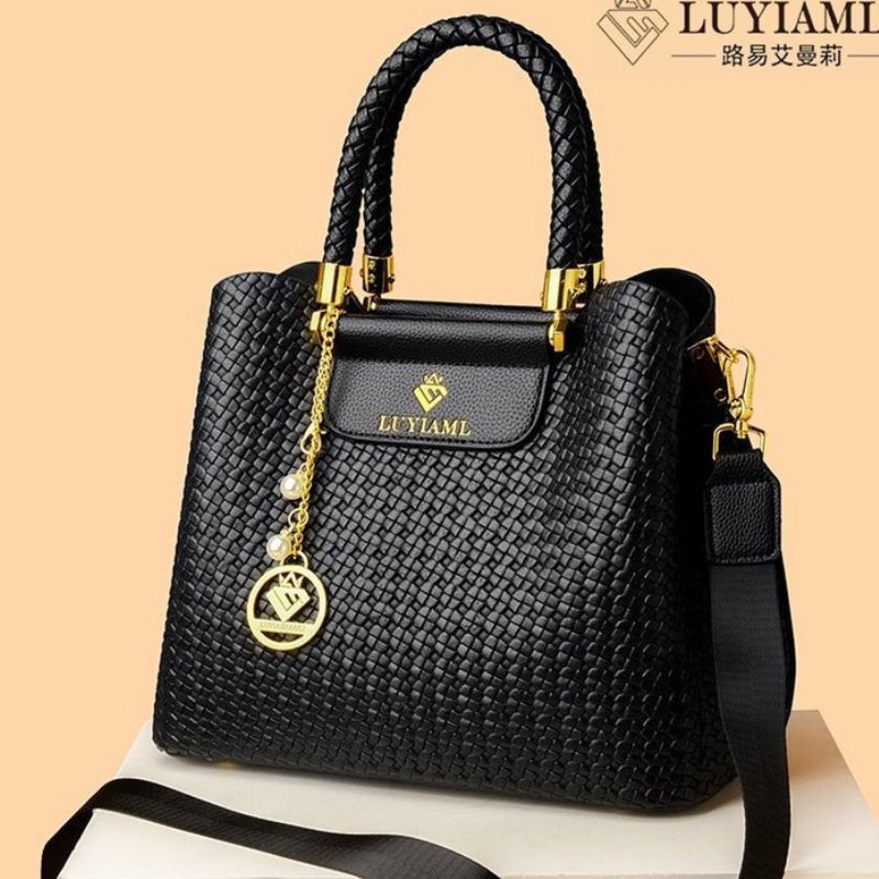 Black handbag with gold accents on a beige background, featuring the LUYIAMI brand.