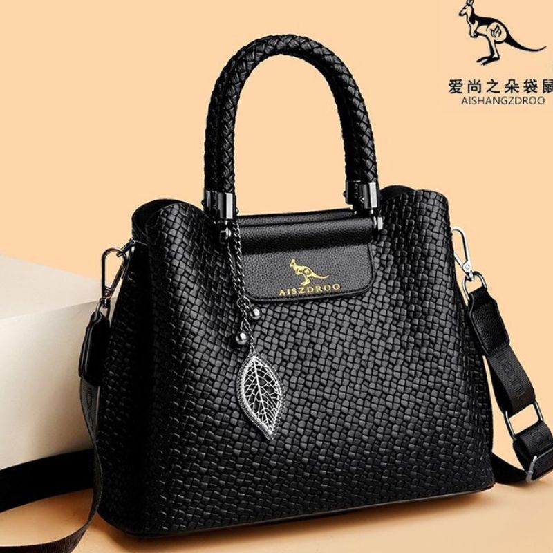 Black textured handbag with a visible brand logo on a beige background