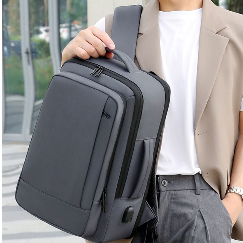 Person holding a gray sling bag outdoors