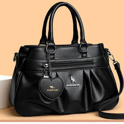 Black handbag with a heart-shaped tag on a beige background