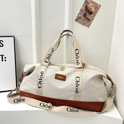 A beige and brown Oxford travelling handbag with adjustable shoulder strap, placed against a white background with the brand name 'Chloe' visible on the strap.