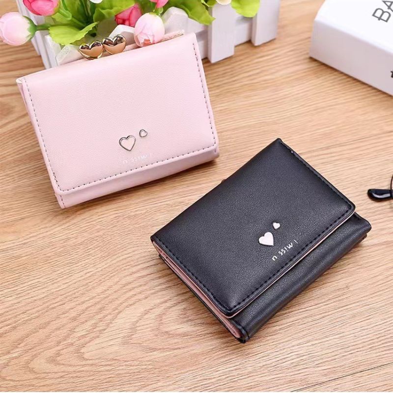 Black wallet with heart design on a wooden surface