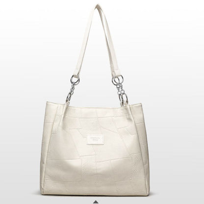 Beige handbag with a textured pattern on a light gray background