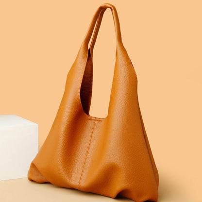 Brown leather handbag on a beige background