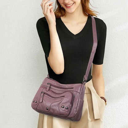 Woman carrying a purple handbag against a plain background