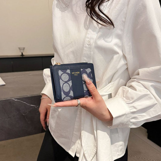 Person holding a blue wallet with a geometric pattern, wearing a white shirt.