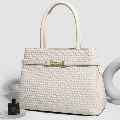 White woven handbag with a gold clasp on a light gray background